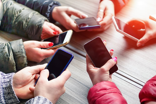 A group of people holding their mobile phones