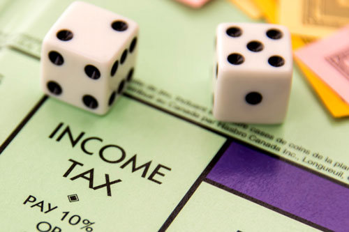 A pair of dice lying on the Income Tax square of a Monopoly board