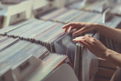 Customer sifting through vinyl records in a shop
