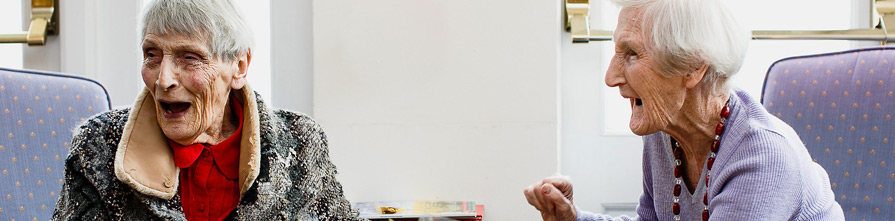 Two elderly ladies (Joyce Webb and Beryl Fox) laughing together at Whiteley Village.