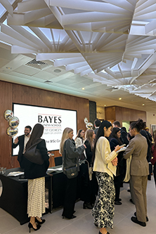 Students in front of a reception desk with led screen behind for the msc careers fair