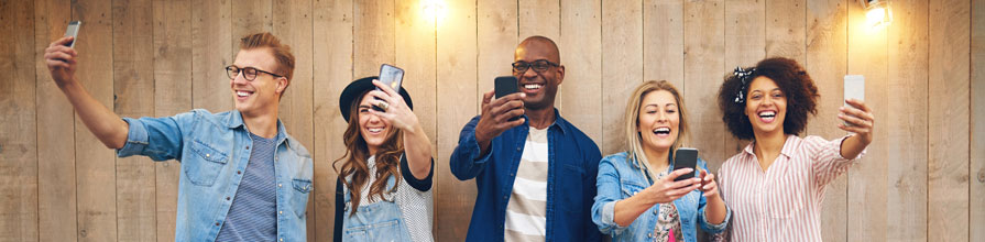 Young group of boys and girls taking selfies together