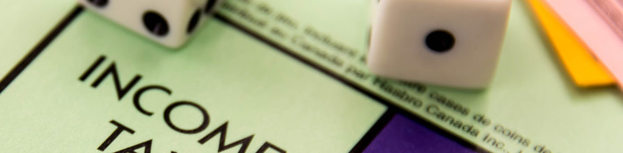 A pair of dice lying on the Income Tax square of a Monopoly board