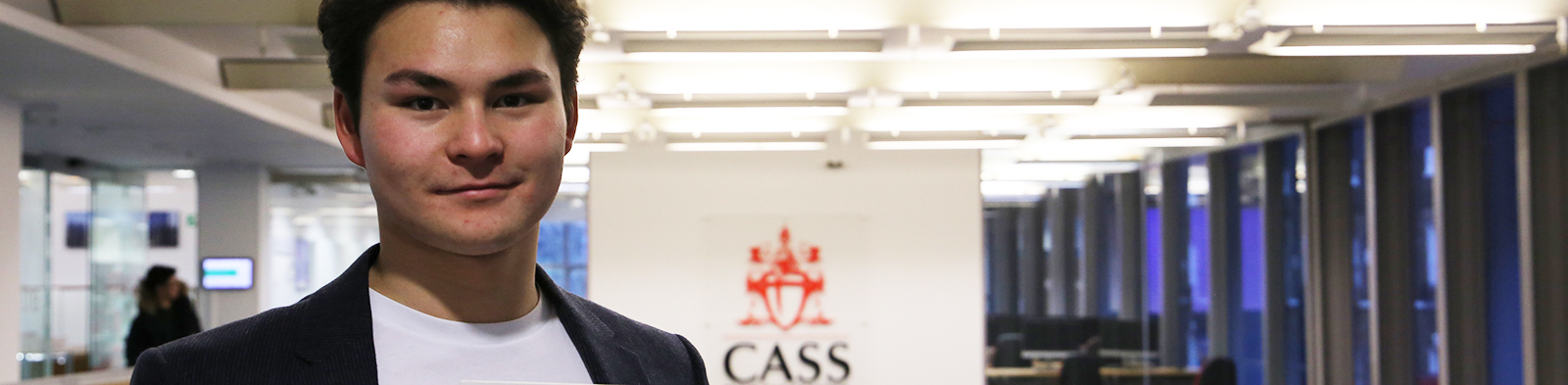 man standing in front of cass business school logo