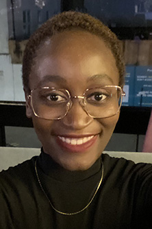 A selfie of of Suko Ndlovu, a female with short hair, dark skin, smiling at the camera