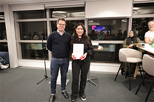 A woman with a certificate and a man smile