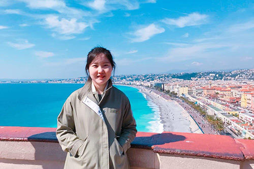 Yiqi Chang in front of a beach