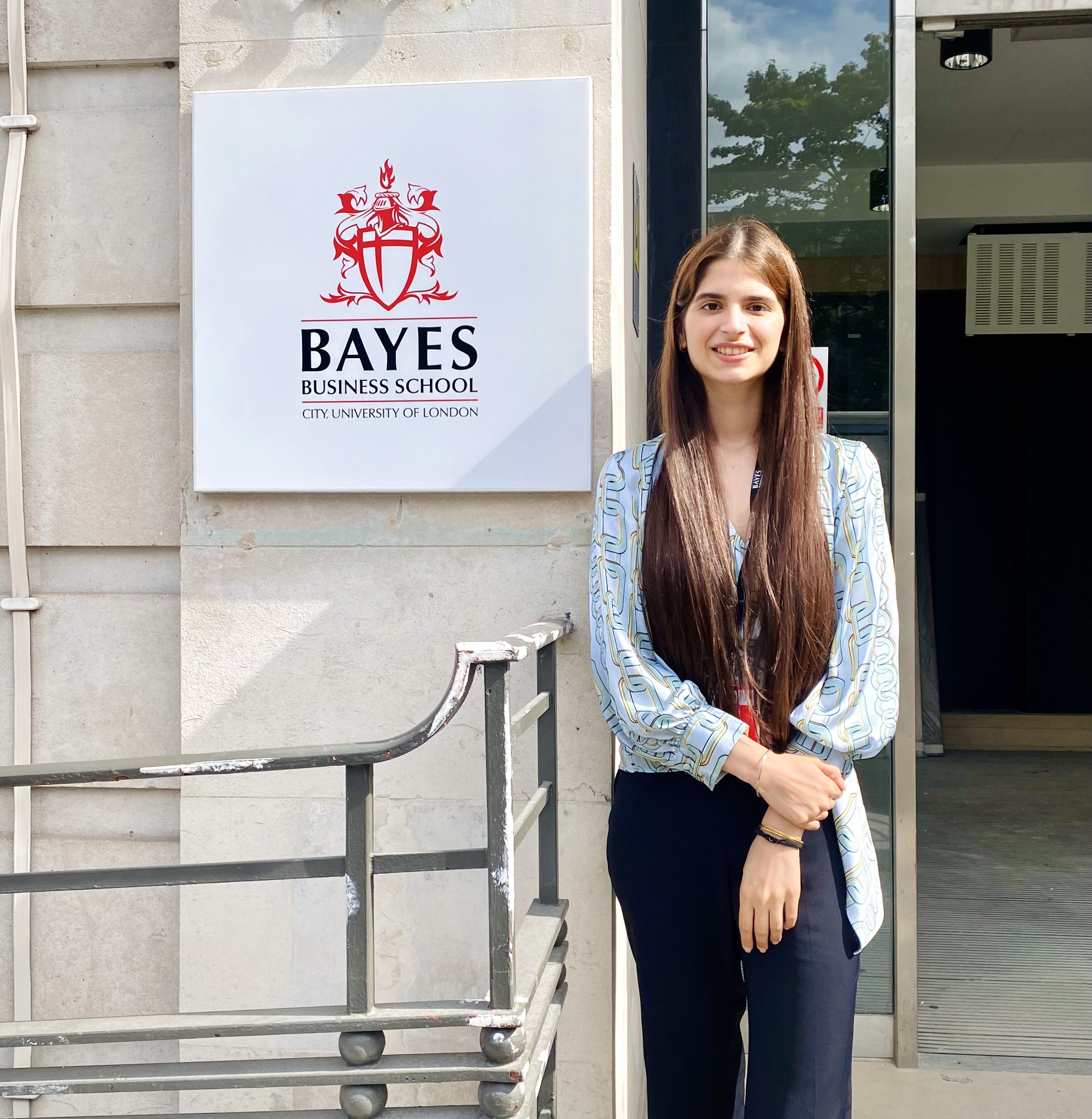 Gunisha standing next to Bayes logo
