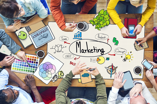 Hands round a table planning a marketing strategy