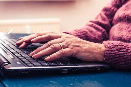 Old person typing on a laptop
