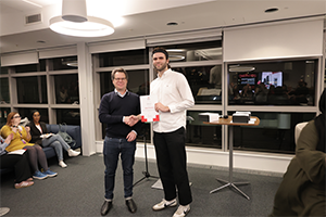 Two men smile - one with a certificate