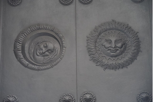 Images of the sun and the moon sculptured into a large door