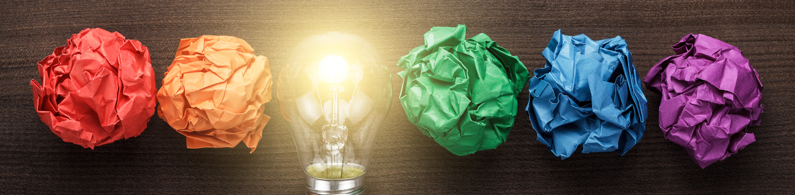 A lightbulb lined up next to scrunched up bits of paper