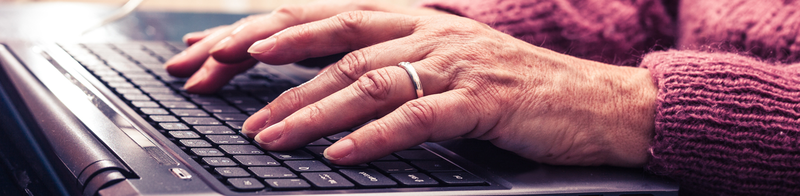 Old person typing on a laptop