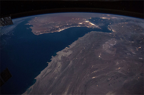 Lights are just visible on a nightime shot of the coastline
