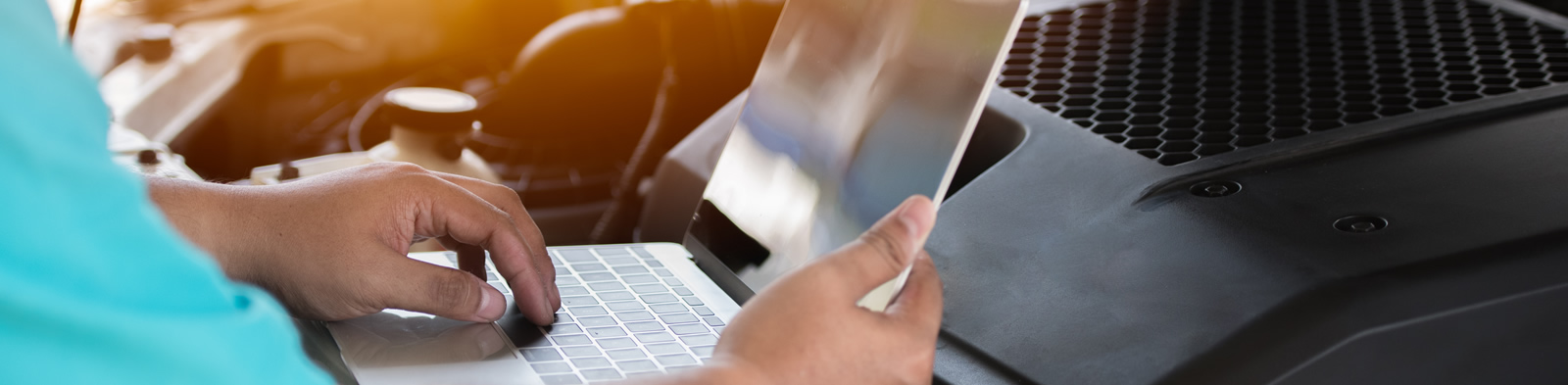 Mechanic checking the software system of a car with laptop
