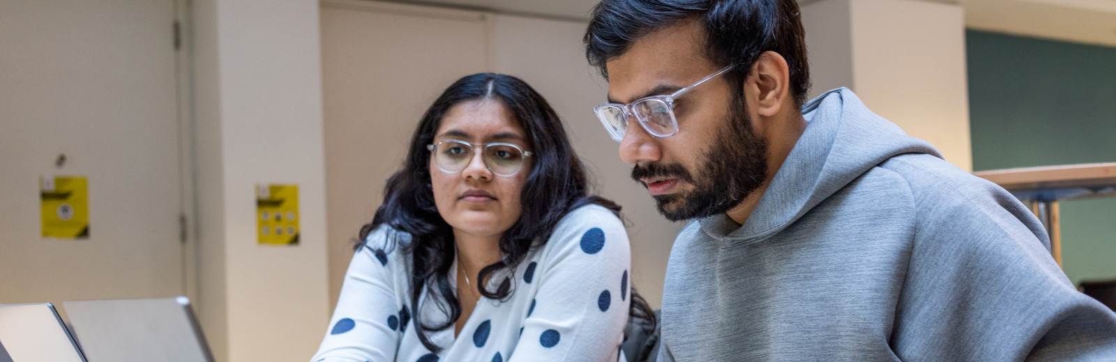 Two students looking at a laptop