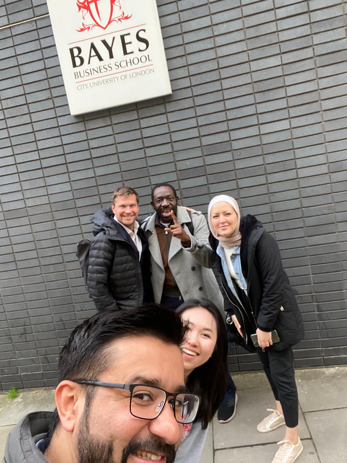 Photo of Samia and friends in front of Bayes sign