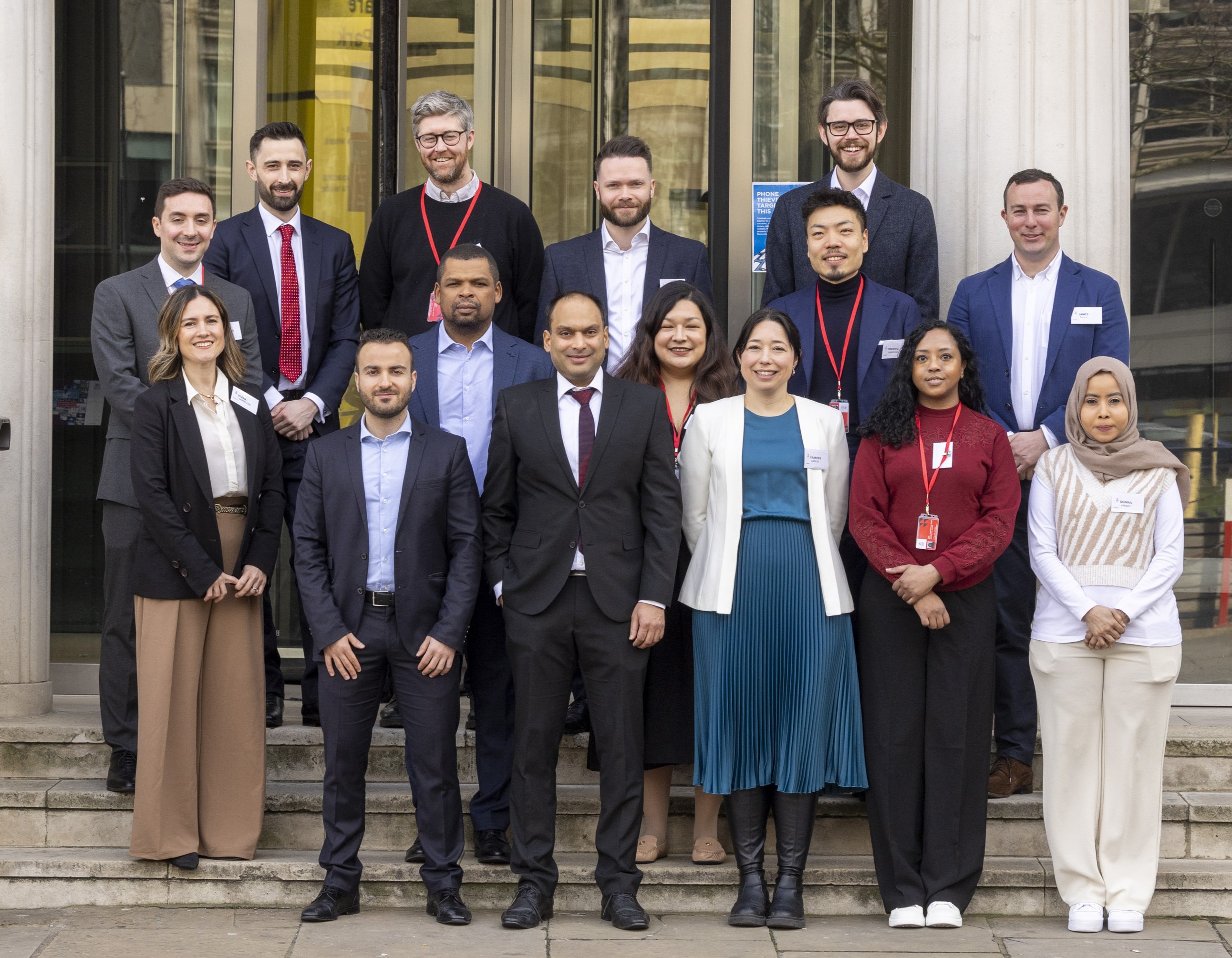 A class of postgrad students standing in front of Bayes