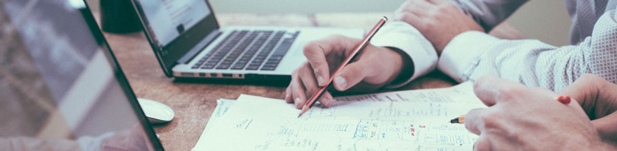 Close up of two people working on laptops. 