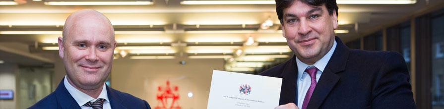 Prize winner Barrie Ingman receives his certificate of merit from WCIB Liveryman Omiros Sakiras