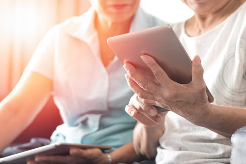 Senior citizens checking their finances on an electronic tablet