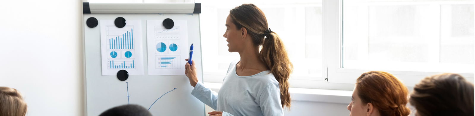 Women presenting figures to colleagues in the boardroom