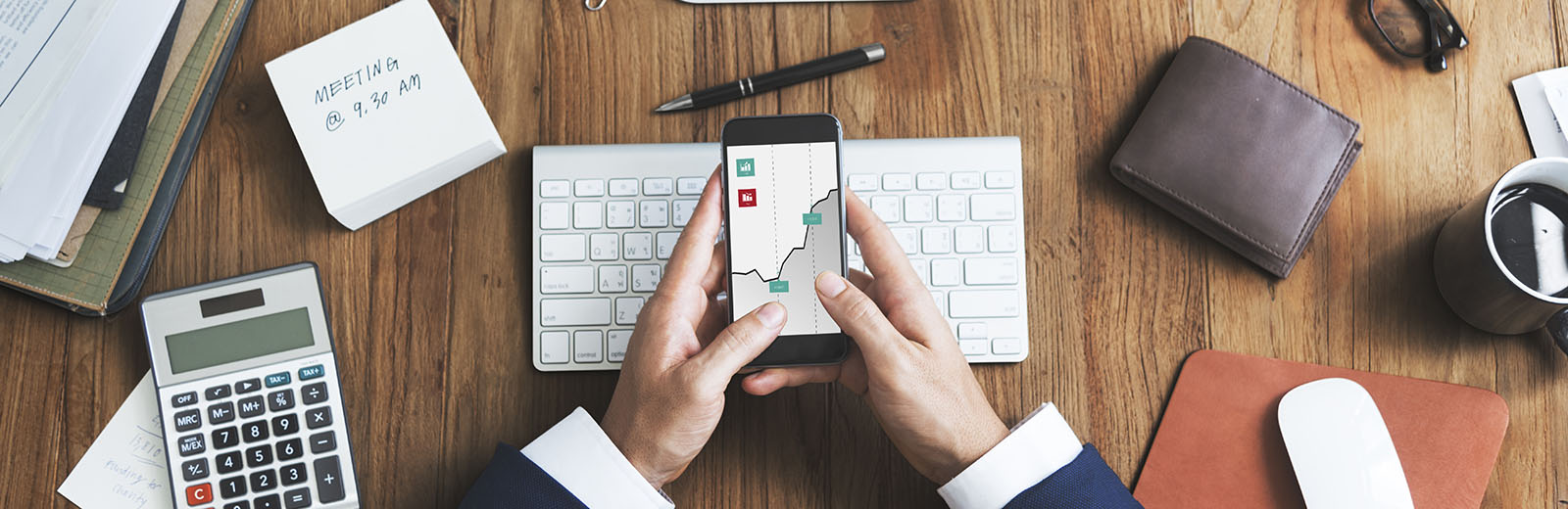Professional viewing a graph on their phone at their desks