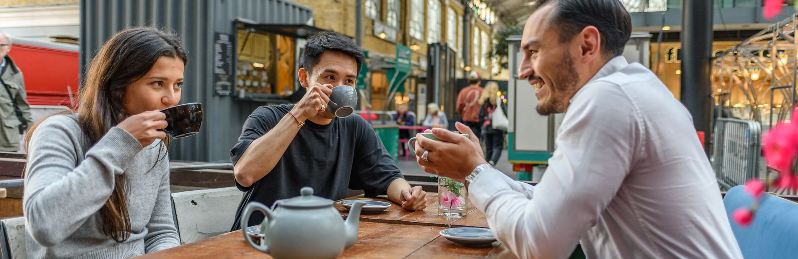 Students drinking tea at a cafe in a covered market.