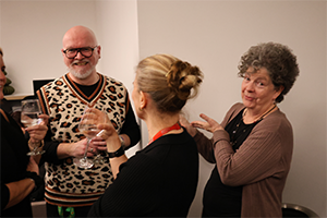 A man smiles while with two women