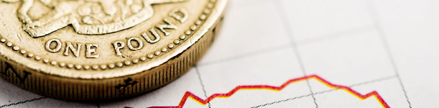 A pound coin sits on a fluctuating graph