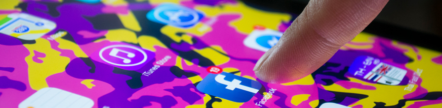 Finger touching Facebook app icon