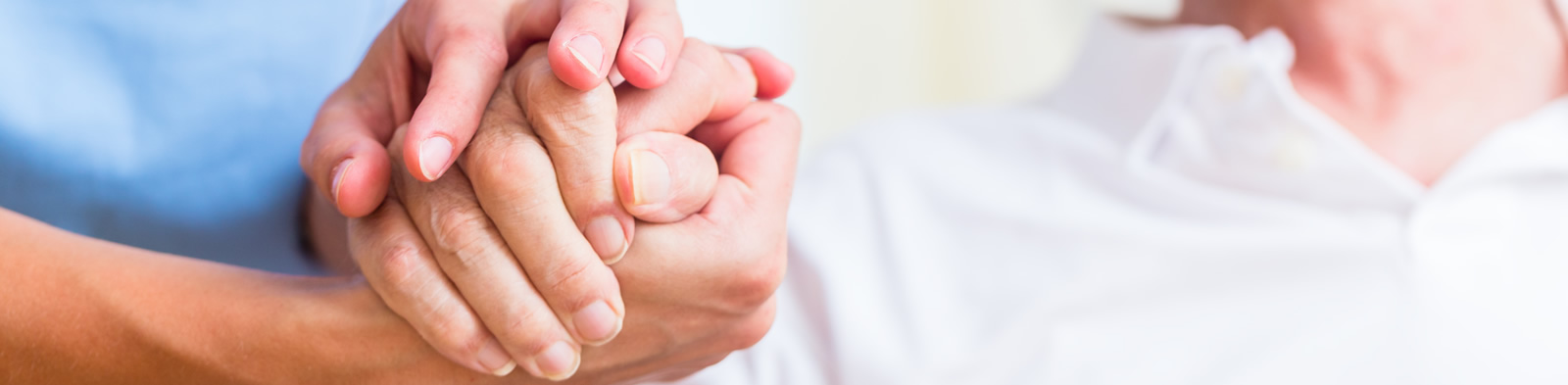 Nurse holding hand of a senior man in a rest home