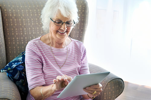 Senior citizen looking at an electronic tablet