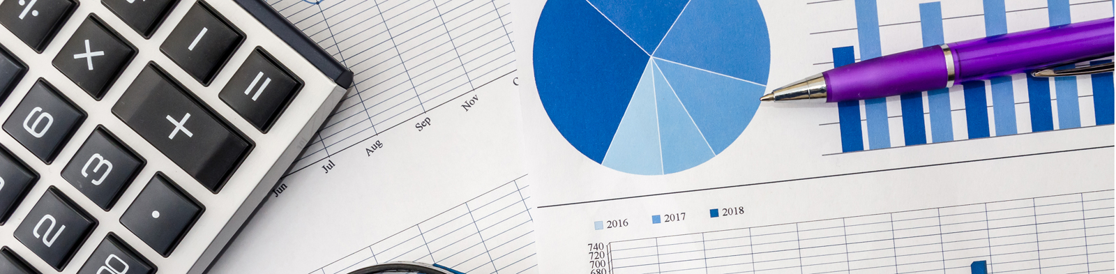 a pile of graphs, with a magnifying glass and calculator